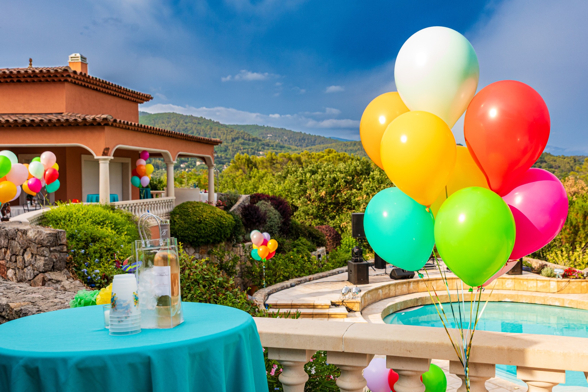 Colourful balloons beside the pool at a private anniversary party